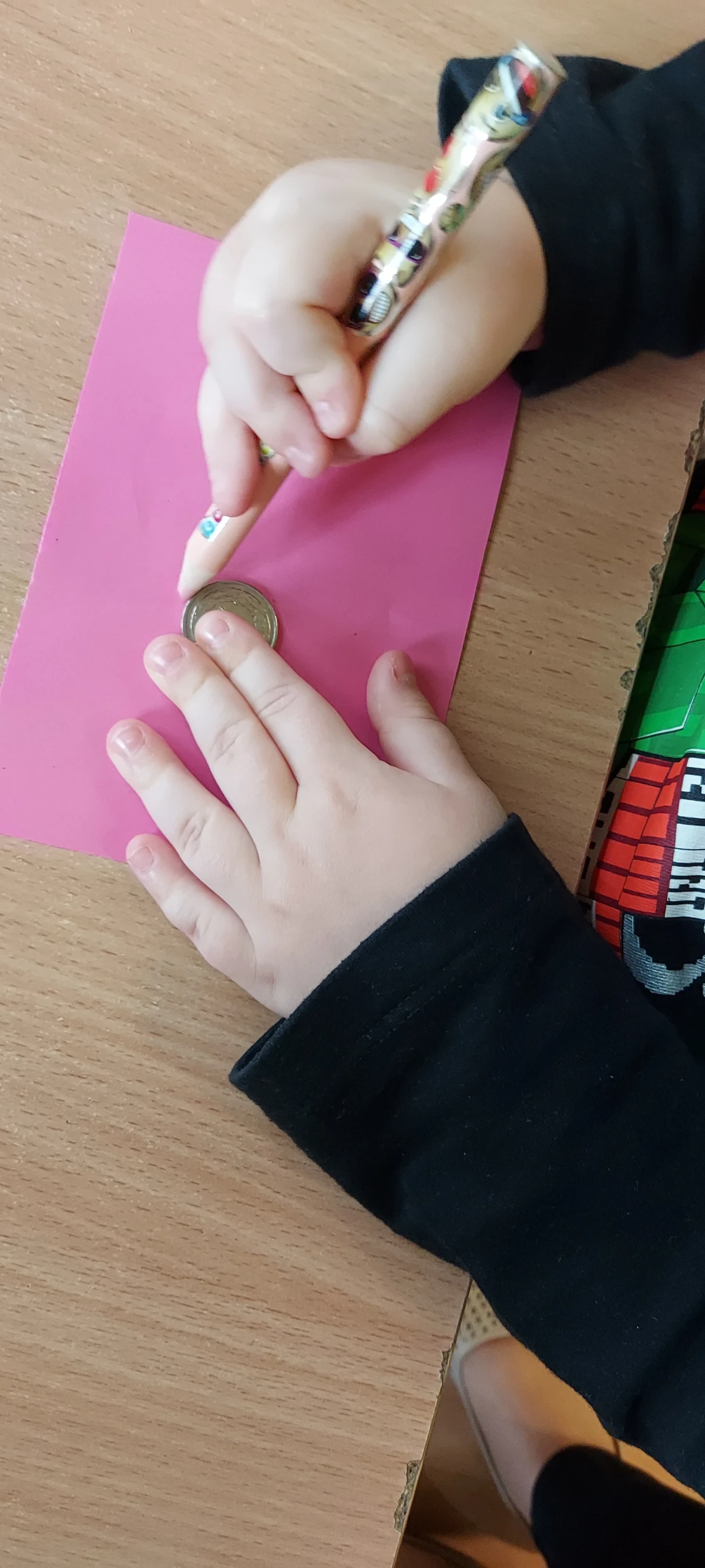 Dziecko obrysowujące monetę